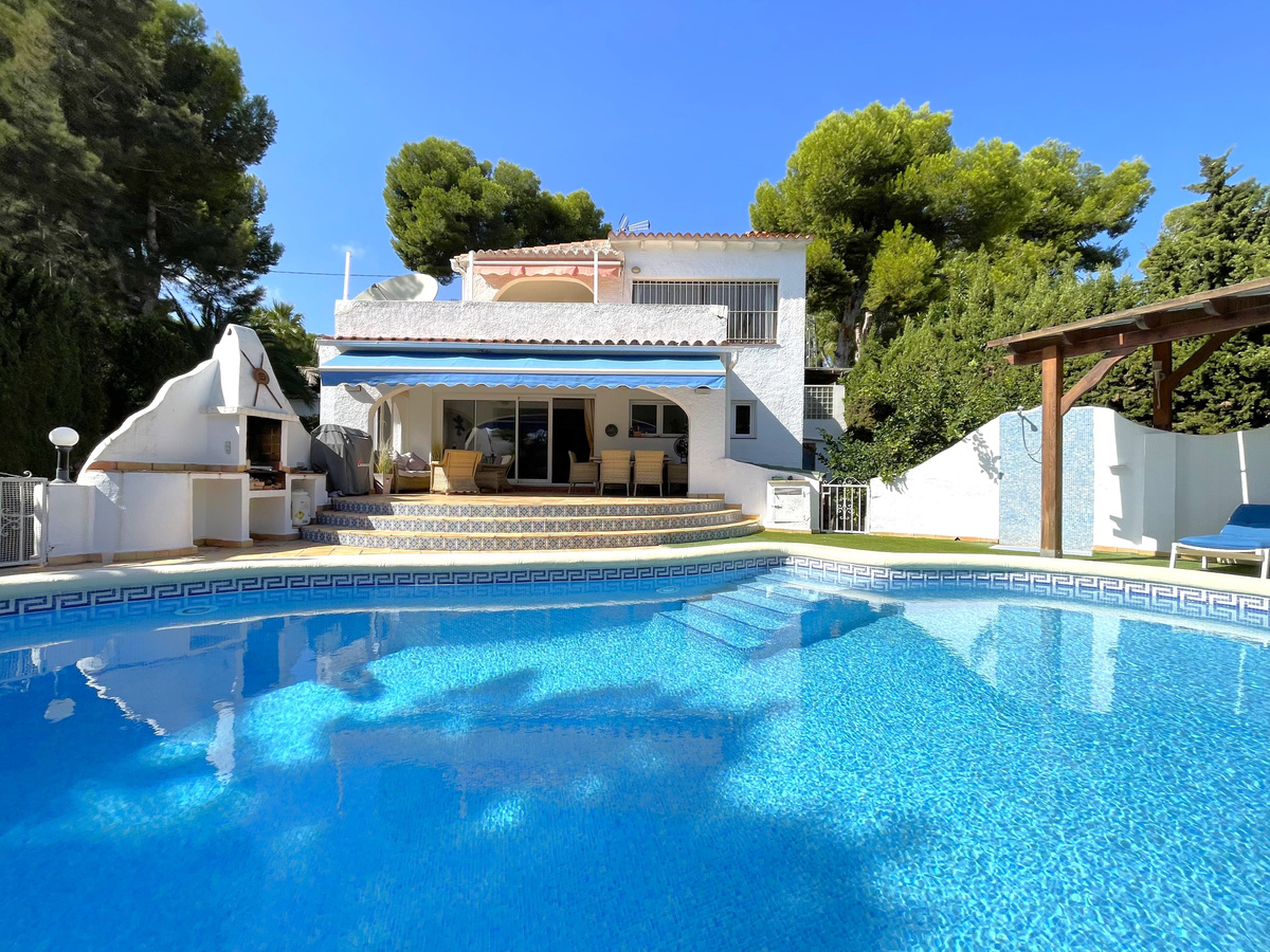A four bedroom, three bathroom villa divided in to two separate apartments with an adjacent plot and tennis court, Moraira